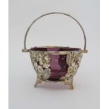 A silver plate basket with floral decoration and swing handle with amethyst glass liner. 4 3/4"