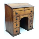 An early 19thC kneehole fruit wood clerks desk having one long drawer three pairs of graduated