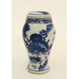 A Chinese blue and white lidded vase decorated with images of a Qilin and a male Foo dog resting its