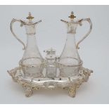 A silver plate four bottle cruet stand with oil and vinegar bottles, salt and pepper. The whole