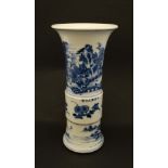 A Chinese blue and white zun shaped vase with flared rim. Decorated with scenes of figures in