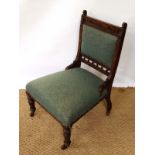 A late Victorian walnut nursing chair with overstuffed seat and back pad and carved decoration. 32