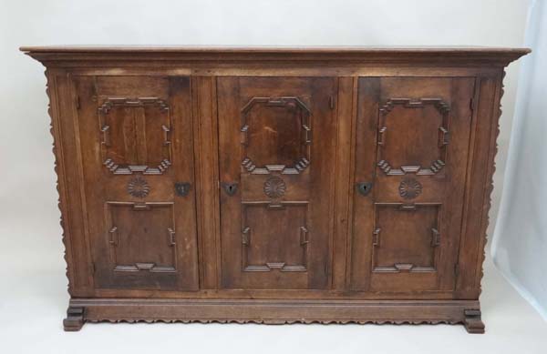 An early 20thC German oak 3 door cupboard with geometric like framed panelling, the doors opening to - Image 15 of 20