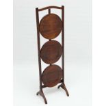 A 1930's Mahogany 'Lazy Susan' cake stand of 3 folding circular tiers ,standing 32 1/2" high