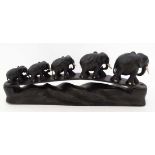 An early 20thC ebony carving of a Troop / Parade of graduated elephants crossing a bridge  , 15"