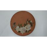 An early 20th C Watcombe Torquay charger. Decorated with white roses on a terracotta ground.