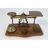 A c1900 set of postage balance scales, complete with weights (7) mounted upon a shaped oak base. 9