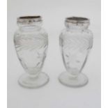 A pair of glass vases of pedestal form with floral and foliate cut decoration and silver rims