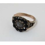 A 19thC yellow metal mourning ring having rock crystal central section with lock of hair bordered by