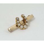 A gilt metal bar brooch with horseshoe to centre set with seed pearls 1 1/4" wide  CONDITION: Please