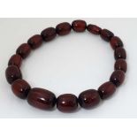 A 20thC necklace of graduated cherry amber style plastic beads. The string approx 20 1/2" long,