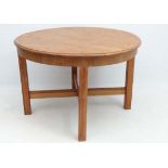 Vintage Retro : an English Heals type circular blonde oak table with four square legs united by a