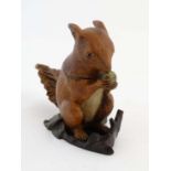 A polychromed cast cold painted bronze model of a squirrel eating an acorn with hinged head formed