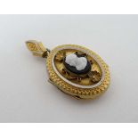 A gilt metal locket having monochrome cameo decoration to centre approx 1 1/2" long  CONDITION: