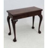 An 18thC mahogany Irish card table with fold over top, concertina action legs and carved knees the