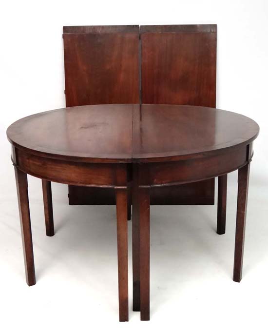 A c.1800 mahogany D-ended extended dining table comprising 2 demi lune tables and 2 leaves with