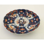 A Japanese Imari style plate., having hand coloured details, the reverse decorated in blue and white