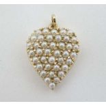 A yellow metal pedant of heart form set with seed pearls 1" high  CONDITION: Please Note -  we do
