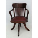 A c.1900 oak swivel office chair with leather upholstered seat open arms, slat back etc 32 1/4" high