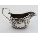 A 19thC Continental silver miniature cream jug with floral and C-scroll decoration and Victorian