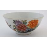 A Chinese famille rose bowl decorated with images of Chrysanthemums on rocks, bears blue Chinese