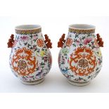 A pair of hu-form Chinese famille rose vases decorated with Chinese symbols, bats and dragons, the