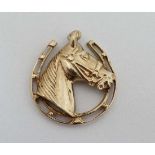 A 9ct gold pendant / charm formed as a horses head within a horseshoe. Approx 1" high  CONDITION: