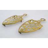 A Victorian pair of pierced and cast brass trivets, bearing registration no. 129936.  8 1/2" long