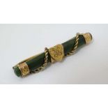 A late 19thC / early 20thC  yellow and gilt metal bar brooch with central jadeite bar with rope