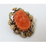 A late 19thC / early 20thC brooch set with central carved coral cameo within an ornate gilt  metal