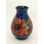 A small Moorcroft Pottery vase in ' Anemone '  pattern on a dark blue ground, mid 20th C.  Marked WM