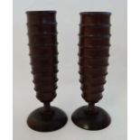 A pair of African carved  hardwood vases with ribbed bodies on circular bases. 11 1/2" high