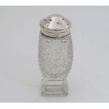 A cut glass sugar dredger with hobnail cut decoration and pedestal foot, with silver top