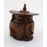 A Japanese carved wooden tobacco pot in the form of figure wearing a hat. The whole 8" high