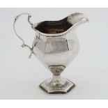 A silver cream jug of hexagonal pedestal form. Hallmarked Birmingham 1916 maker Henry Williamson Ltd