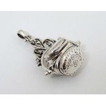 A white metal pendant fob with revolving locket sections to centre 1 3/4" high  CONDITION: Please