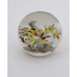 An Art glass paperweight with stylized floral decoration and various inclusions. Approx 2 1/4"