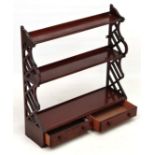 A late 20thC mahogany open wall hanging waterfall set of shelves with pierced sides and two