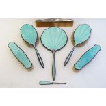 An Art Deco silver and green guilloché enamel dressing table set comprising hand mirror, brushes etc