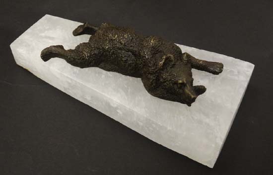 A patinated bronze figure of a recumbent bear upon a rock crystal base. 9" long  CONDITION: Please