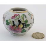 A miniature Chinese famille rose pot, decorated in polychrome with images of butterflies in a floral