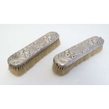 A pair of Victorian HM silver backed brushes with floral and foliate decoration dated London 1887,