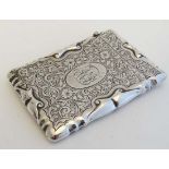 A silver card case with scroll detail and engraved floral and acanthus scroll decoration, hallmarked