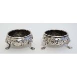 A pair of Geo III HM silver salts of circular form with embossed decoration on 3 feet London 1770 (