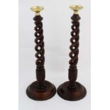 A pair of 20thC triple hardwood open twist candle sticks with circular bases and brass sconces 17