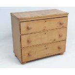 A Victorian stripped pine chest of three graduated drawers standing on squat bun feet 33 3/4" wide x
