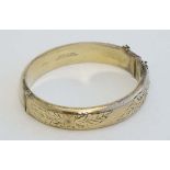 A silver gilt bangle bracelet with engraved floral decoration. Hallmarked Birmingham 1967 maker H.