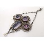 A white metal pendant set with four amethyst coloured cabochon  and pearl drop. 2 3/4" long