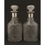 A pair of cut glass decanters with silver collars, hallmarked London 1909. Each 8 1/2'' high.