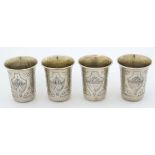 A set of 4 Russian silver vodka cups with engraved floral and building detail and traces of original